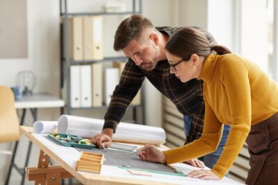 side-view-portrait-two-architects-pointing-floor-plan-while-working-blueprints-workplace_236854-25698 Woodbine: Architectural Expertise - Designing Your Vision